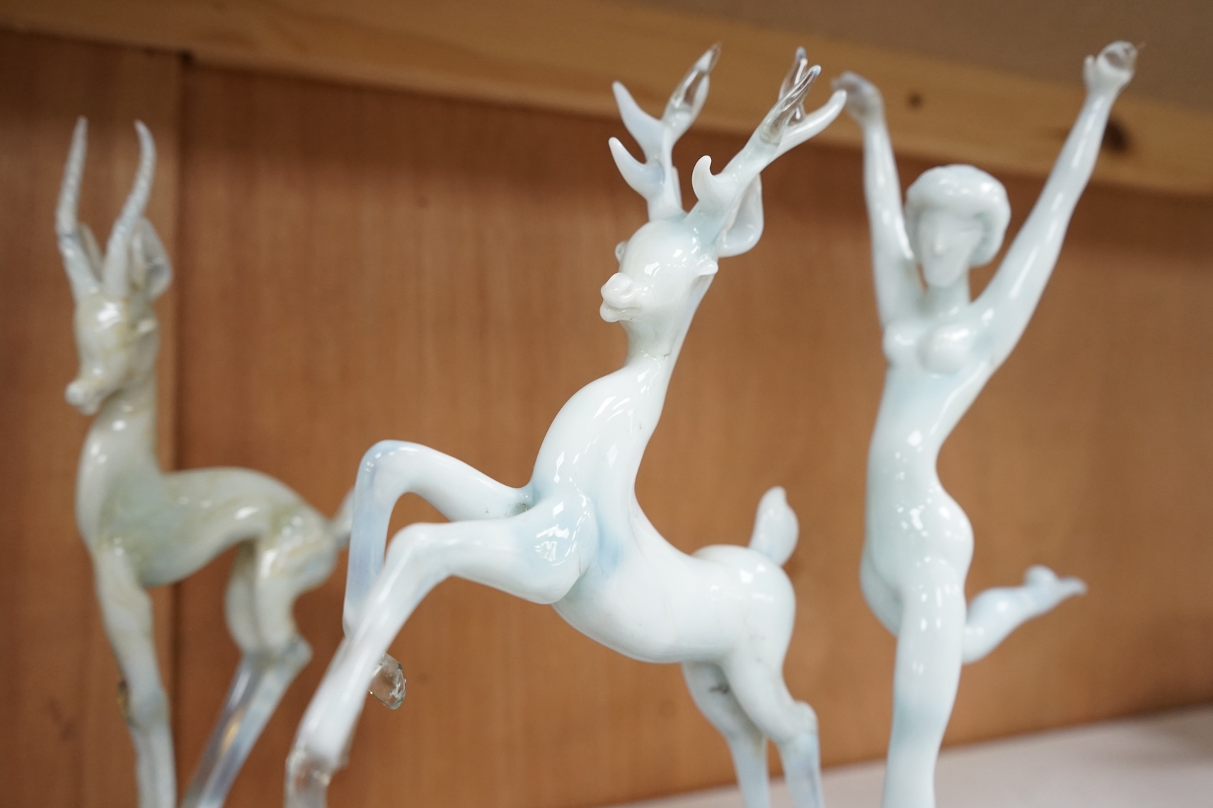 Two Istvan Komaromy glass sculptures, 1950s , one with a dancing lady and stag the other of a deer on a ball, together with a group of three later art glass dishes, tallest 26cm high., Condition - foot to deer on ball ch